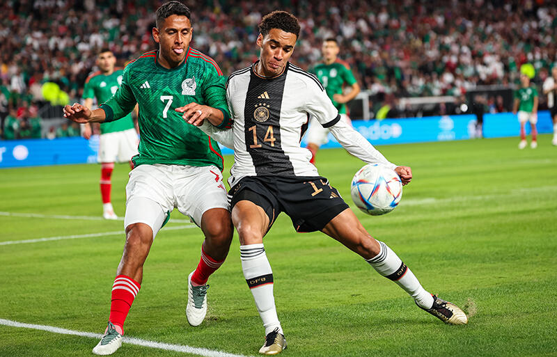 競り合うドイツ代表MFジャマル・ムシアラとメキシコ代表MFルイス・ロモ