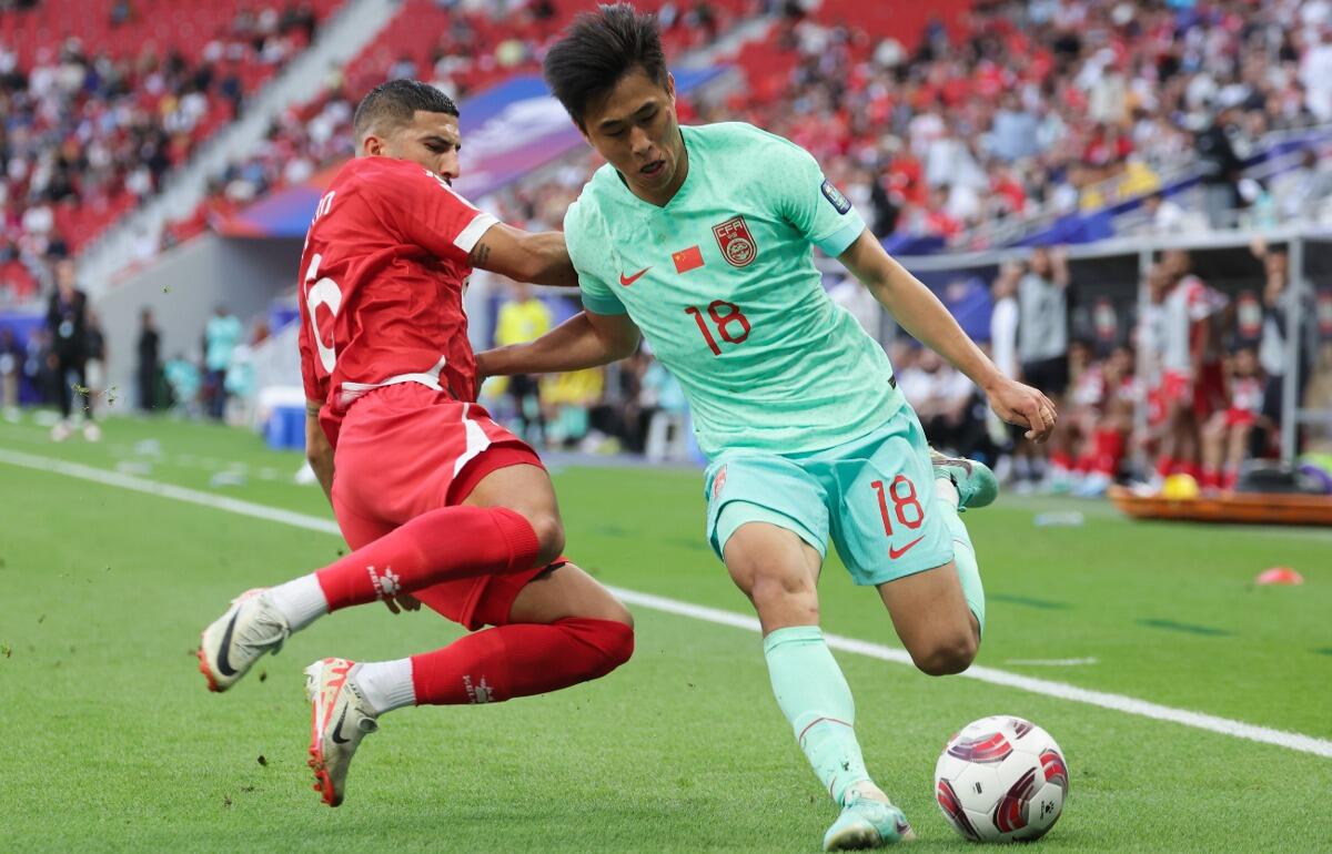 相手のスパイクが顔に入り裂傷を負った中国代表MFダイ・ウェイチュン(右)